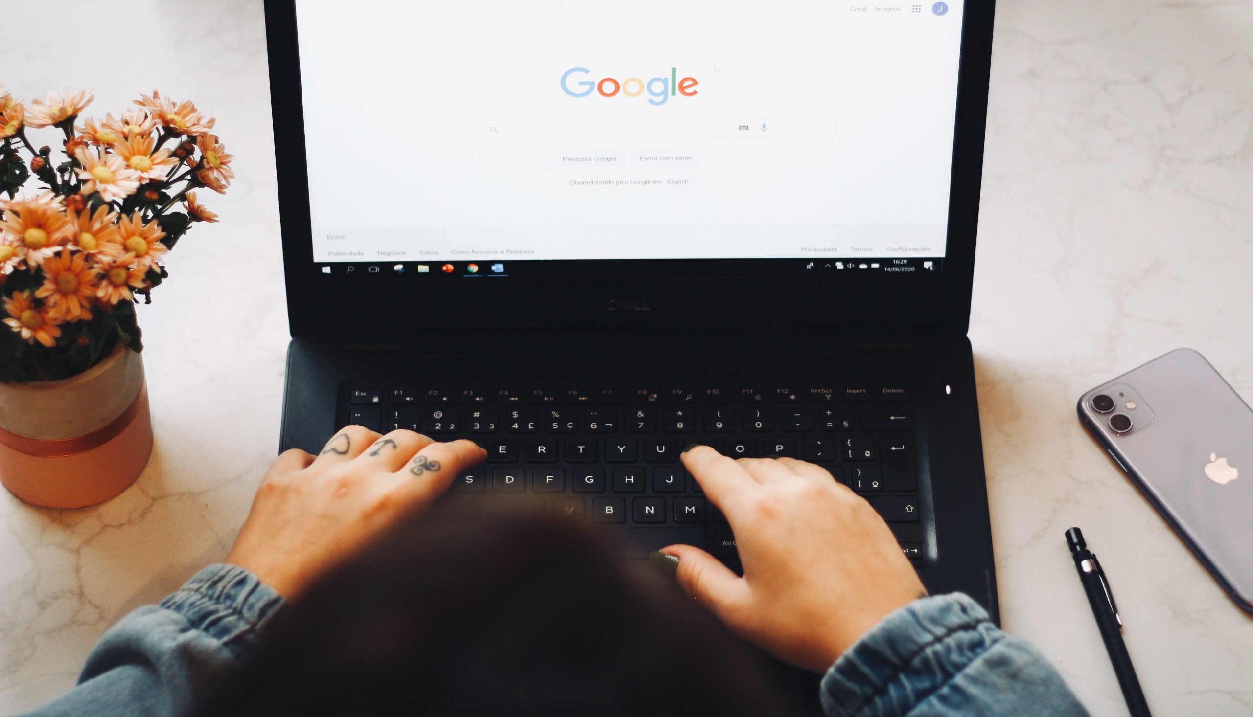 Hands on a laptop keyboard with Google on the screen.